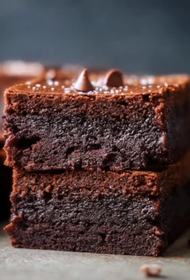 Decadent Cottage Cheese Brownies served on a plate with chocolate drizzle