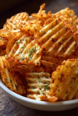 Cottage cheese chips seasoned with paprika and dill, displayed on a plate.