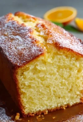 Freshly baked Orange Loaf Cake with a citrus glaze on a wooden table