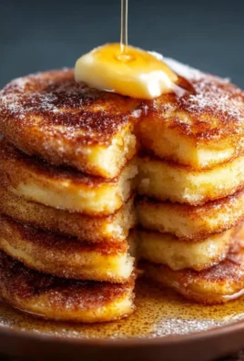 Delicious churro pancakes drizzled with chocolate sauce and sprinkled with cinnamon sugar