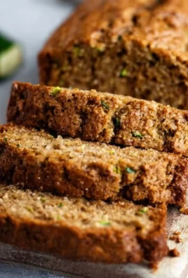 Loaf of homemade best zucchini bread with slices on a wooden table