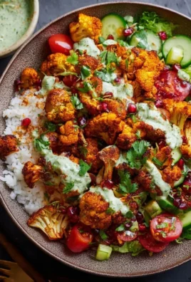 Delicious cauliflower shawarma bowl garnished with fresh vegetables and sauce