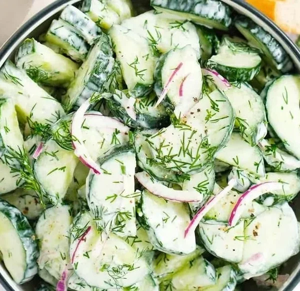 Fresh cucumber dill salad served in a bowl with herbs and spices.