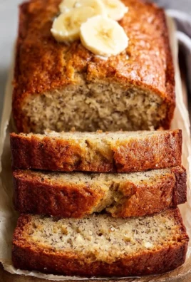 Slice of easy moist banana bread on a wooden cutting board