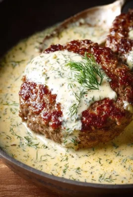 Delicious hamburger steaks served with creamy dill sauce on a plate