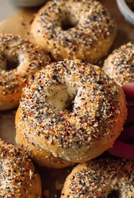Homemade everything bagels fresh from the oven, topped with seasoning.