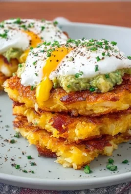 Loaded hash browns topped with cheese, bacon, and green onions on a plate