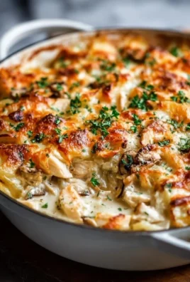 Delicious Rotisserie Chicken Casserole topped with cheese and herbs