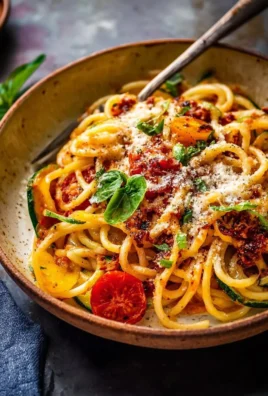 A colorful bowl of spring pasta with fresh vegetables and herbs