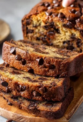 Slice of super moist chocolate chip banana bread on a wooden board