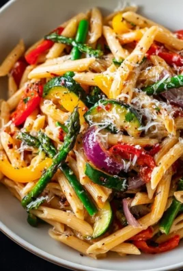 Plate of colorful Vegetarian Pasta Primavera with fresh vegetables and herbs