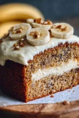 Delicious banana bread cake with cream cheese frosting served on a plate
