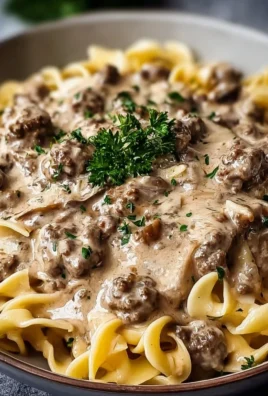 Creamy hamburger stroganoff served in a bowl with fresh herbs