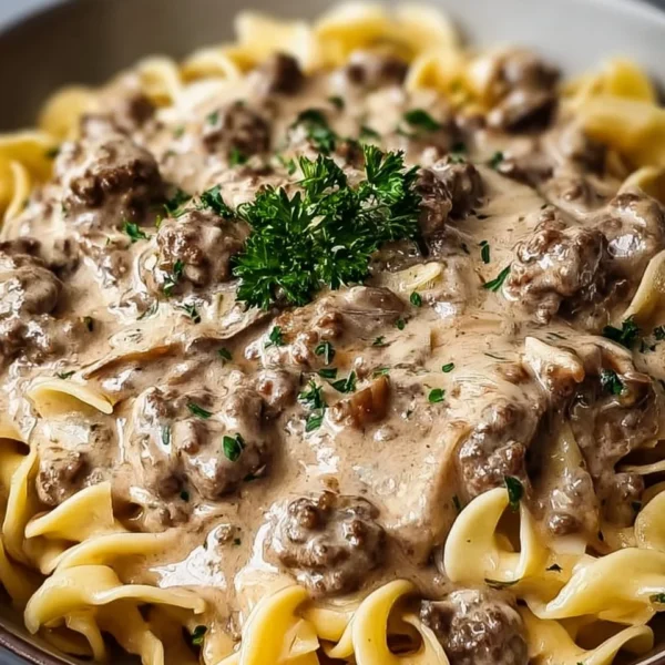 Creamy hamburger stroganoff served in a bowl with fresh herbs