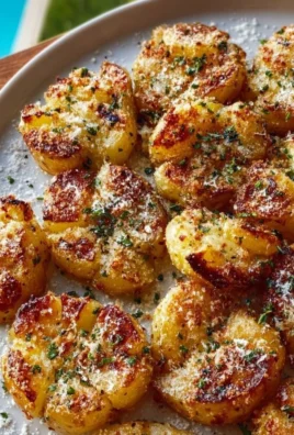 Crispy garlic butter parmesan smashed potatoes served on a plate