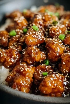 Plate of sesame chicken garnished with sesame seeds and vegetables