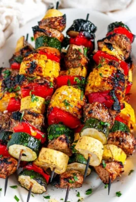 Balsamic chicken vegetable kabobs on a grill, ready to be served.