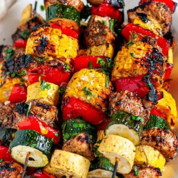 Balsamic chicken vegetable kabobs on a grill, ready to be served.