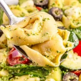 Cold tortellini pesto salad with vegetables and fresh herbs