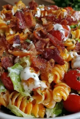 Delicious creamy BLT pasta salad in a bowl with fresh ingredients.