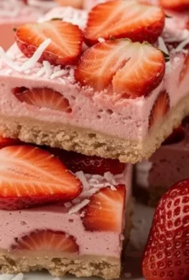 Creamy strawberry coconut bars served on a plate with fresh strawberries