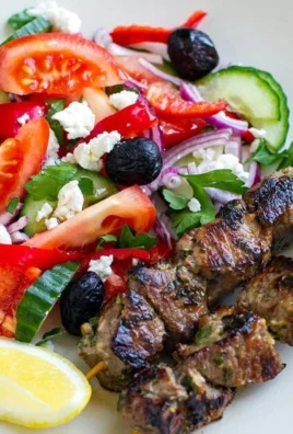 Plate of Greek souvlaki lamb served with a fresh salad