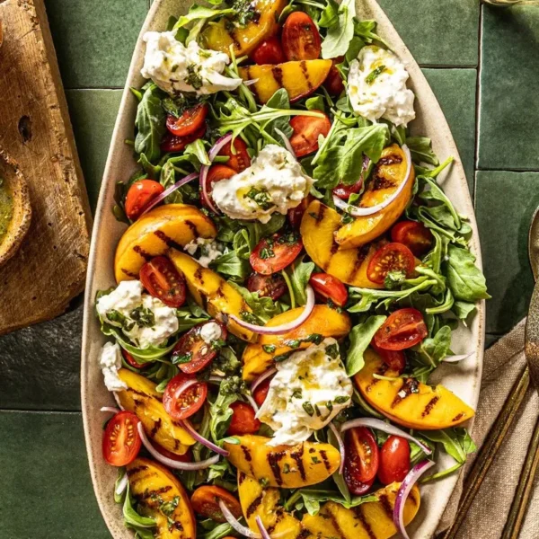 Grilled Peach Burrata Salad garnished with Basil Mint Vinaigrette