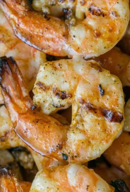 Delicious grilled shrimp skewers served on a plate with fresh herbs.
