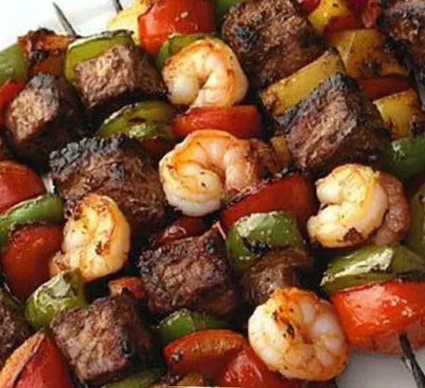 Grilled steak and shrimp kabobs on a skewer ready for serving