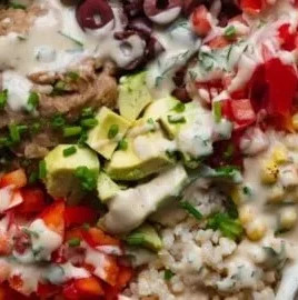 High-protein refried bean veggie bowl topped with fresh vegetables and spices