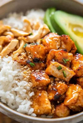 Delicious Hot Honey Chicken Bowls topped with fresh vegetables and sauce
