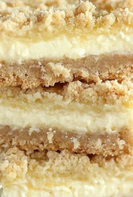 Delicious Lemon Cheesecake Crumb Bars topped with lemon zest and crumbs.