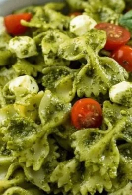 Delicious pesto pasta salad with fresh vegetables and basil