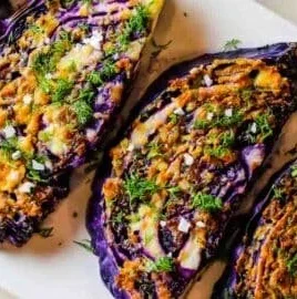 Delicious roasted red cabbage steaks with garlic parmesan topping on a plate.
