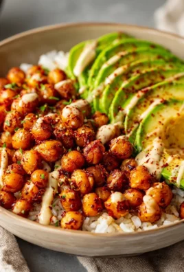 Spicy roasted chickpea and avocado bowls garnished with fresh ingredients