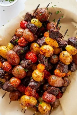 Plate of perfectly grilled steak kabobs with colorful vegetables