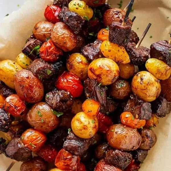 Plate of perfectly grilled steak kabobs with colorful vegetables