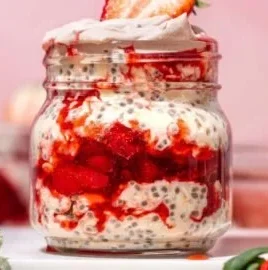 Bowl of strawberries and cream overnight oats topped with fresh strawberries