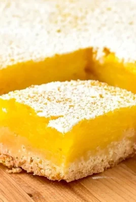 Super easy lemon bars with a tangy filling and buttery crust, sliced on a plate.