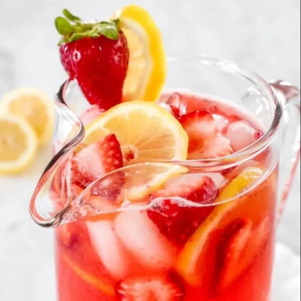 Glass of sweet strawberry lemonade with fresh strawberries and lemon slices