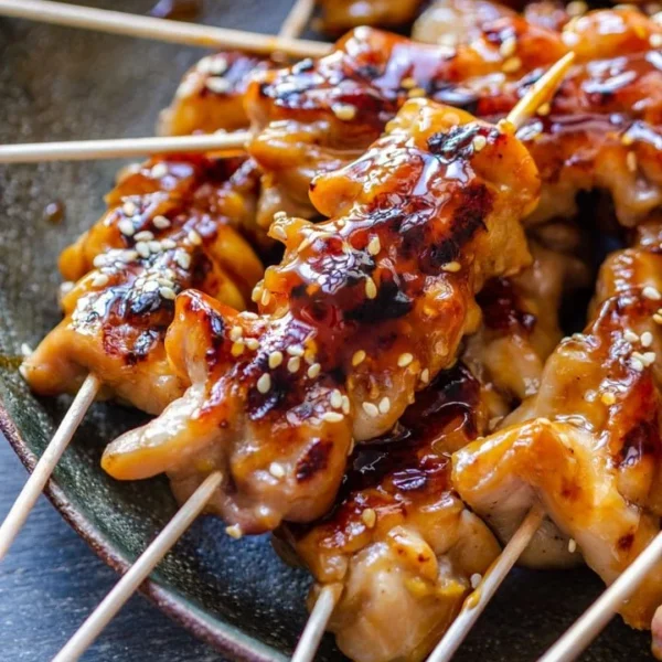 Grilled teriyaki chicken skewers garnished with sesame seeds and green onions