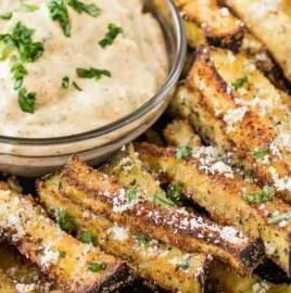 Baked eggplant fries with basil dipping sauce on a plate