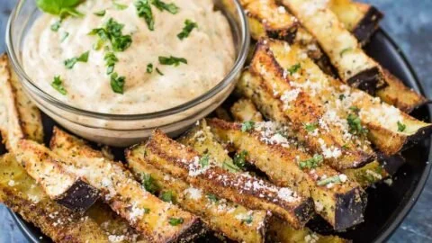 Baked eggplant fries with basil dipping sauce on a plate