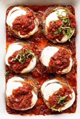 Delicious baked eggplant parmesan topped with cheese and fresh herbs