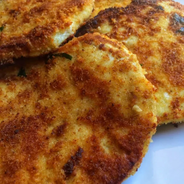 Crispy breaded eggplants served on a plate with dipping sauce