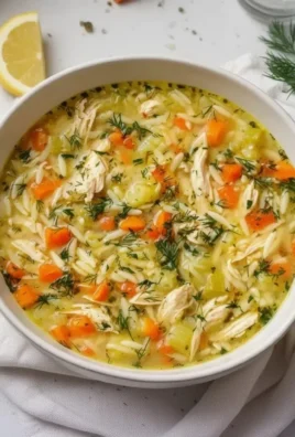 Bowl of Greek Lemon Chicken Soup garnished with lemon and herbs