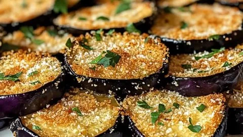Crispy baked eggplant slices on a plate served with herbs and seasoning