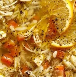 Crockpot Chicken Lemon Soup in a bowl garnished with fresh herbs.
