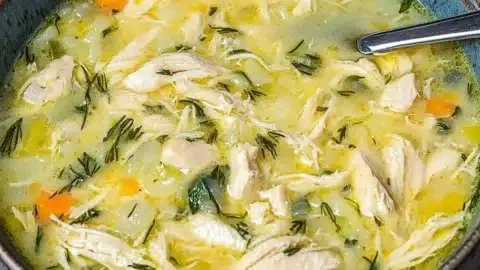 Bowl of Easy Avgolemono, Greek lemon soup with a creamy texture and lemon garnish.