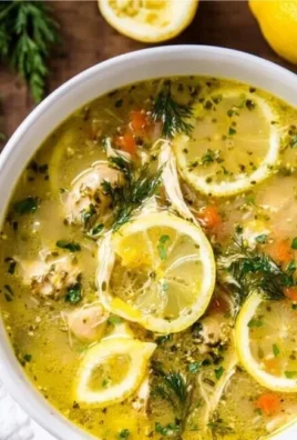 Bowl of Greek Lemon Chicken Soup (Avgolemono) topped with herbs